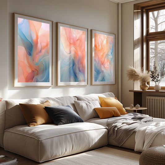 Three abstract canvas prints with swirling blue, orange, and pink accents in a bohemian-styled room