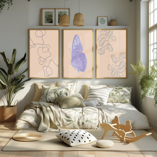 A collection of soft peach-toned prints, featuring a delicate lavender butterfly and abstract forms, displayed in a sunlit bedroom.