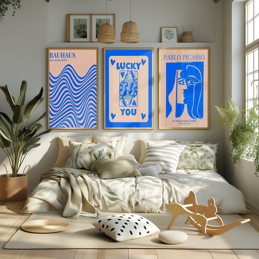 A vibrant set of cerulean artworks with Bauhaus waves, a &#39;Lucky You&#39; playing card, and Picasso&#39;s iconic profile, enlivening a sunny room.