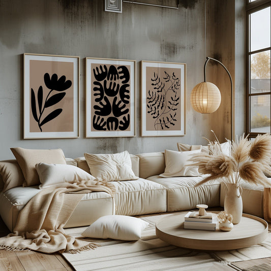 Three striking art pieces with botanical silhouettes in black on a beige background, complementing a rustic chic interior.