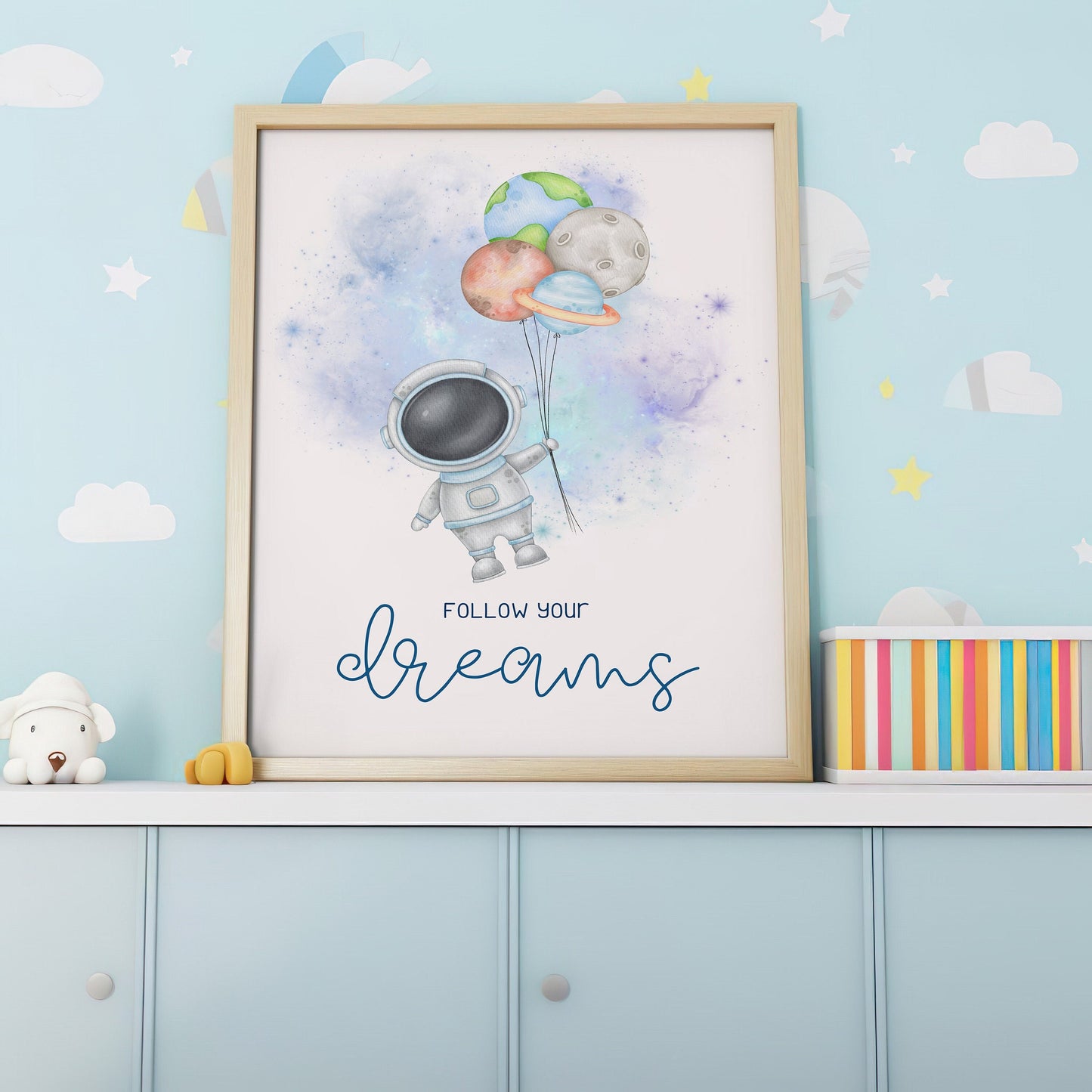 Nursery wall art featuring an astronaut holding planet balloons with the text &quot;Follow your dreams,&quot; perfect for kids room and nursery decor. Available as an instant digital download.