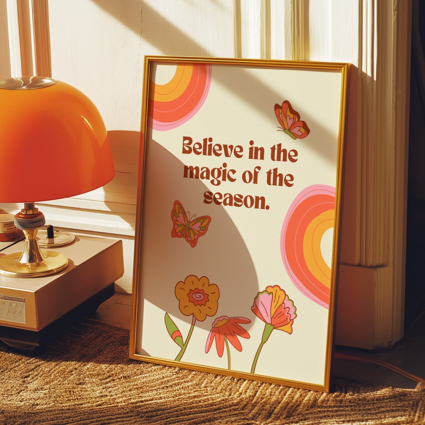 A vibrant art print featuring the phrase &quot;Believe in the magic of the season&quot; with colorful flowers and butterflies.