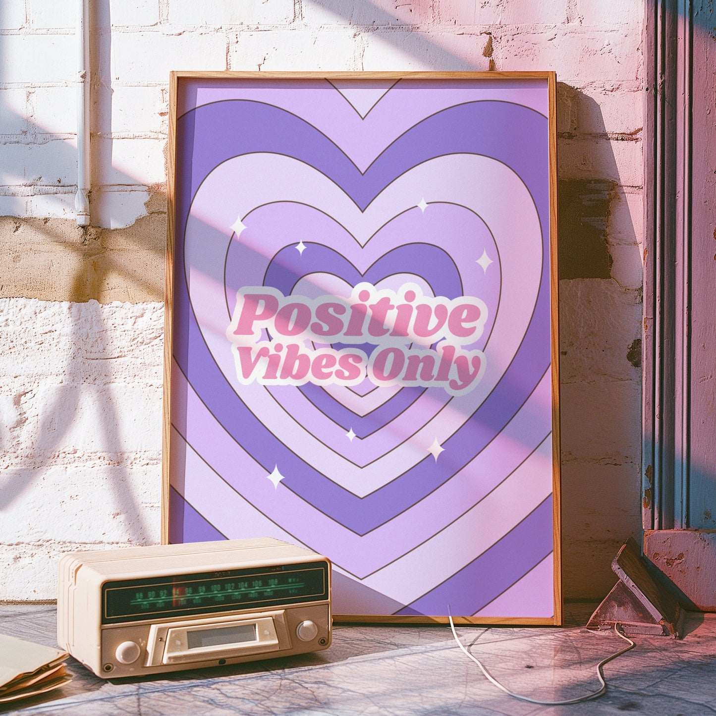 A retro-inspired poster with concentric heart designs in shades of pink and purple, featuring the phrase &quot;Positive Vibes Only&quot; in bold, uplifting text.