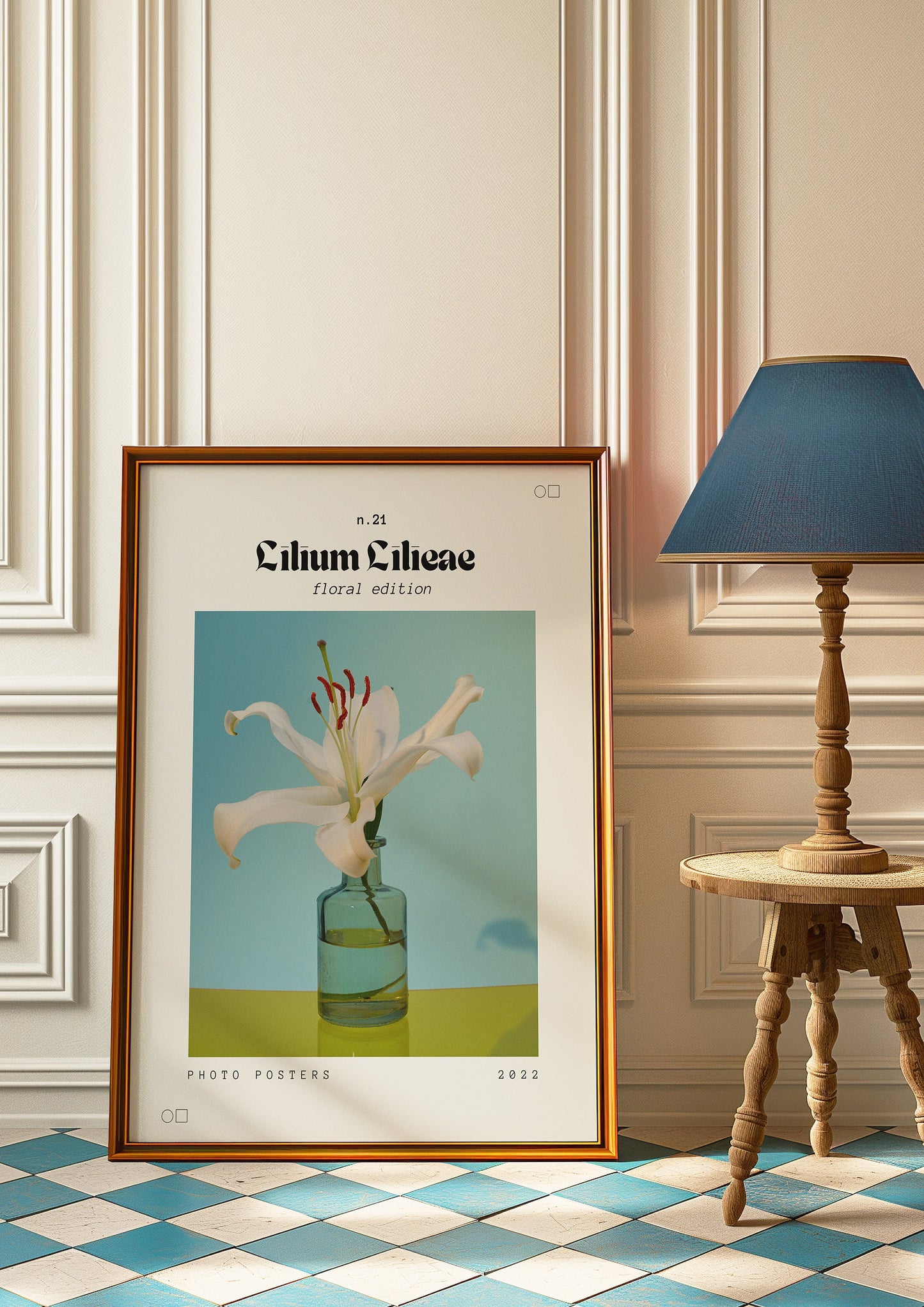 A framed Lilium Lilieae poster featuring a white lily in a glass vase, displayed against a classic cream-colored wall with a wooden table and a blue lampshade, adding an elegant touch to the decor.