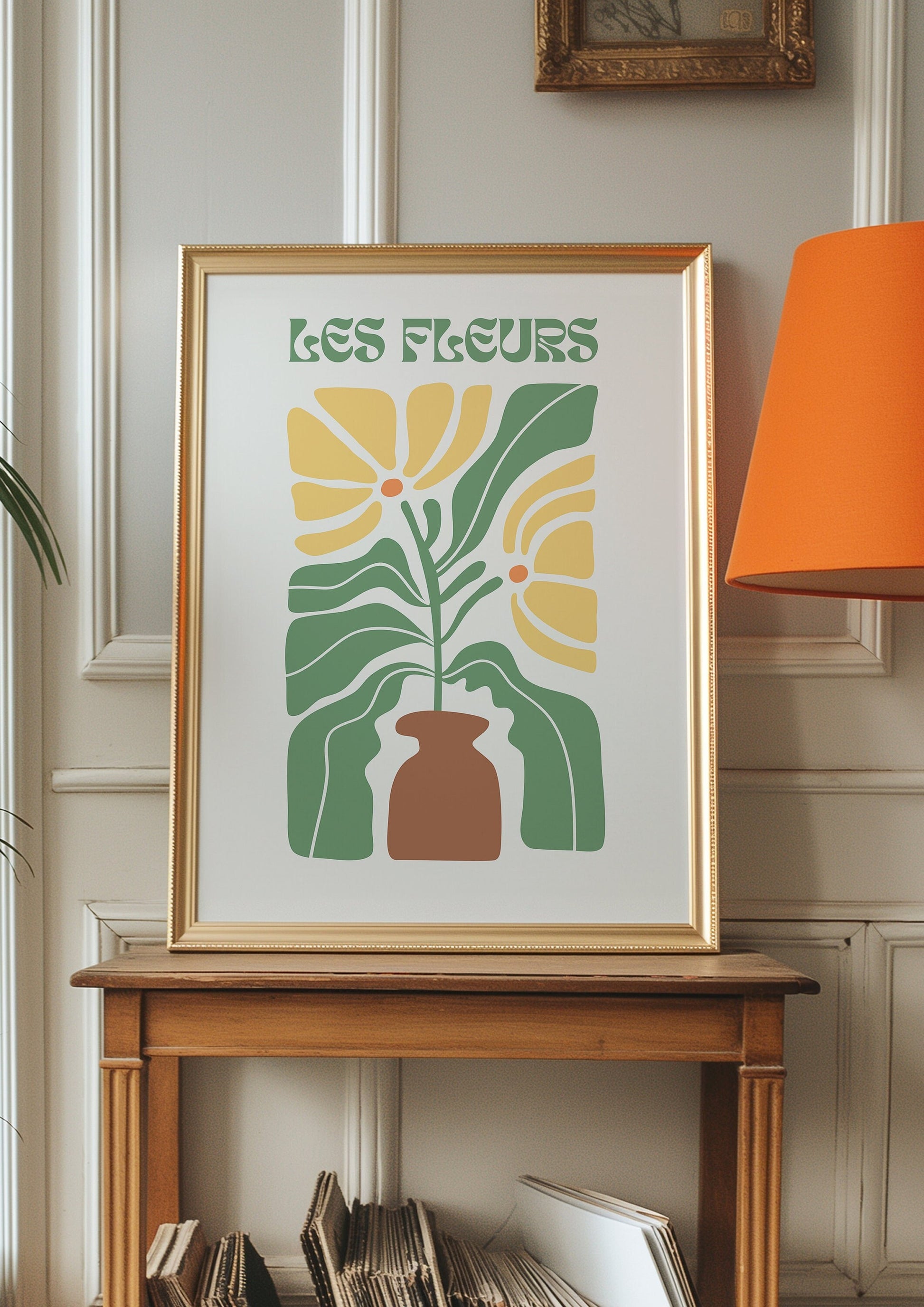 A stylish &quot;Les Fleurs&quot; poster featuring a retro floral design in yellow and green with a brown vase. The artwork is leaning against a white paneled wall next to a large window