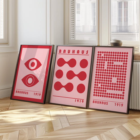 A set of three red Bauhaus posters featuring abstract geometric designs with eyes, circles, and dots. Perfect for adding a bold, modern touch to any room.