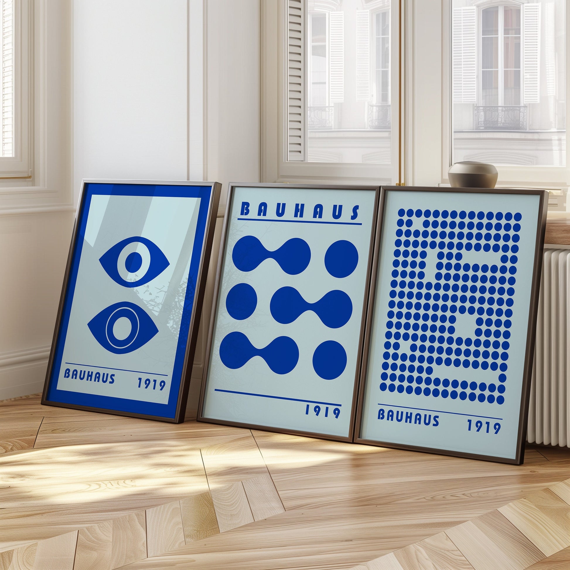 A set of three blue Bauhaus posters featuring abstract geometric designs with eyes, circles, and dots, perfect for adding a bold, modern touch to any room.