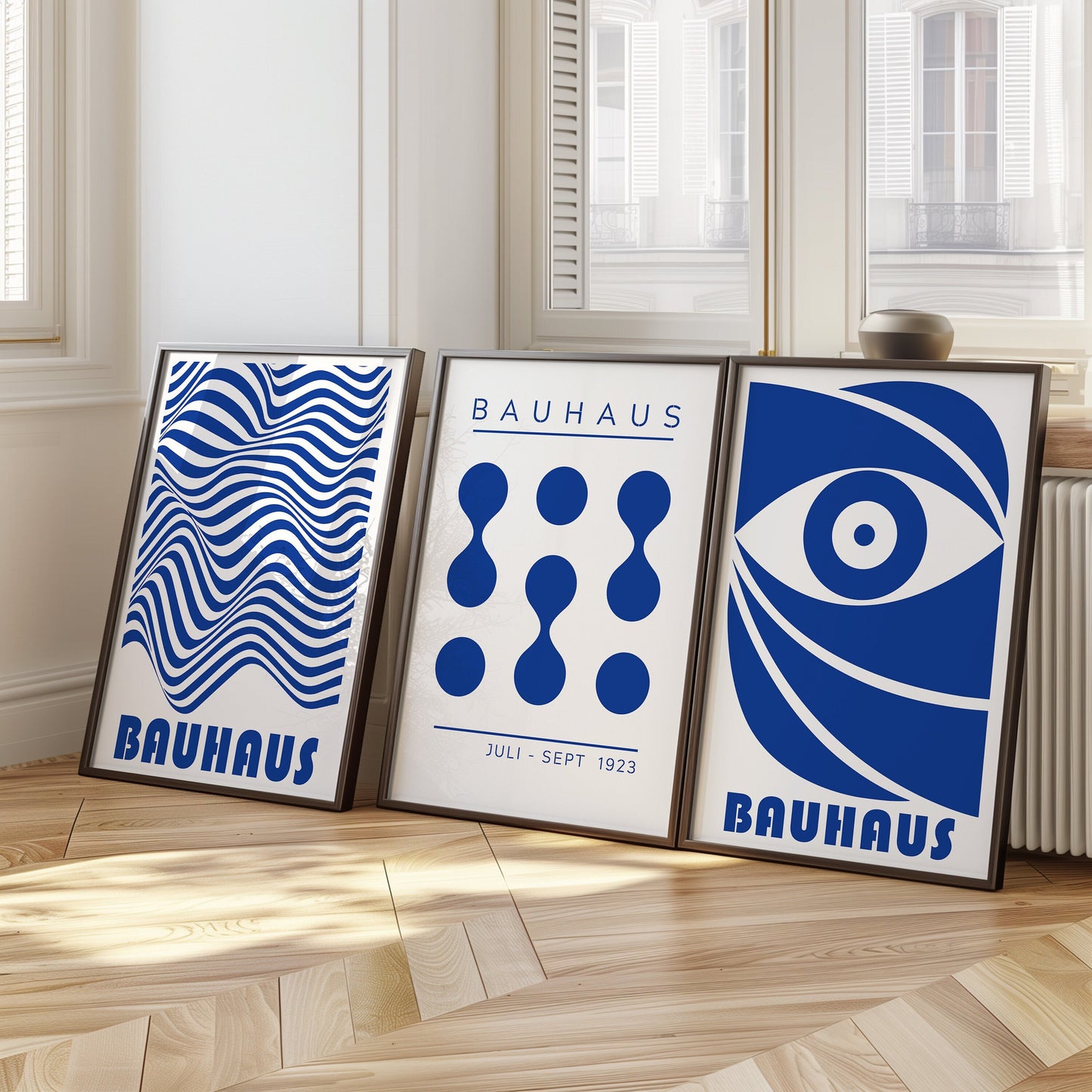 A set of three Bauhaus posters in striking blue, featuring abstract geometric designs including an eye motif, organic shapes, and wavy lines, all representing the iconic Bauhaus style.