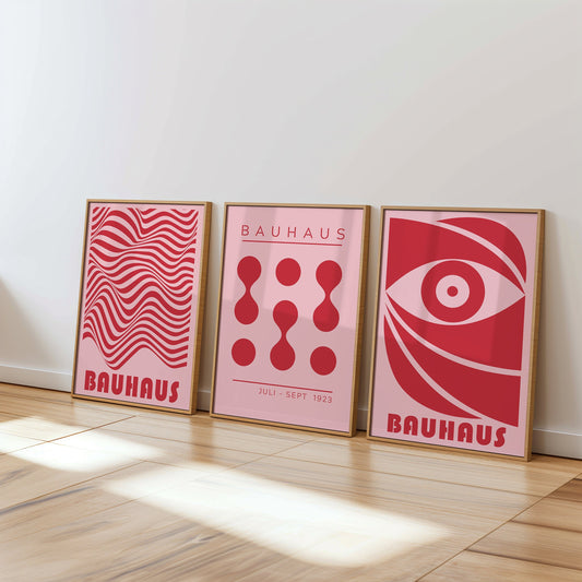 A set of three red Bauhaus posters featuring geometric abstract designs, including an eye symbol, organic shapes, and flowing lines, all in the distinctive Bauhaus style from 1923.