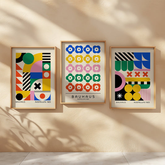 A vibrant set of three Bauhaus posters featuring a mix of abstract geometric patterns and floral designs, framed in light wood, adding a bold and colorful touch to any wall.