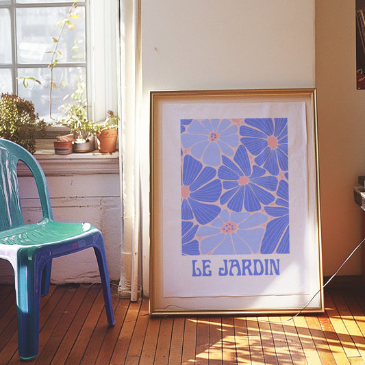 A vibrant poster with a blue and pink floral design titled &quot;Le Jardin,&quot; framed and displayed in a modern living space, reflecting a bohemian French style.