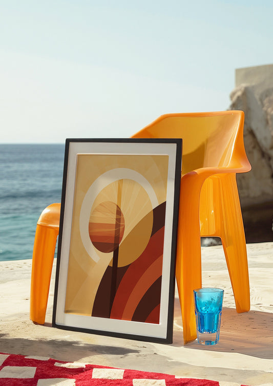 An abstract poster featuring a geometric sun design in warm earth tones, displayed on a wooden console table next to a vase with pampas grass.