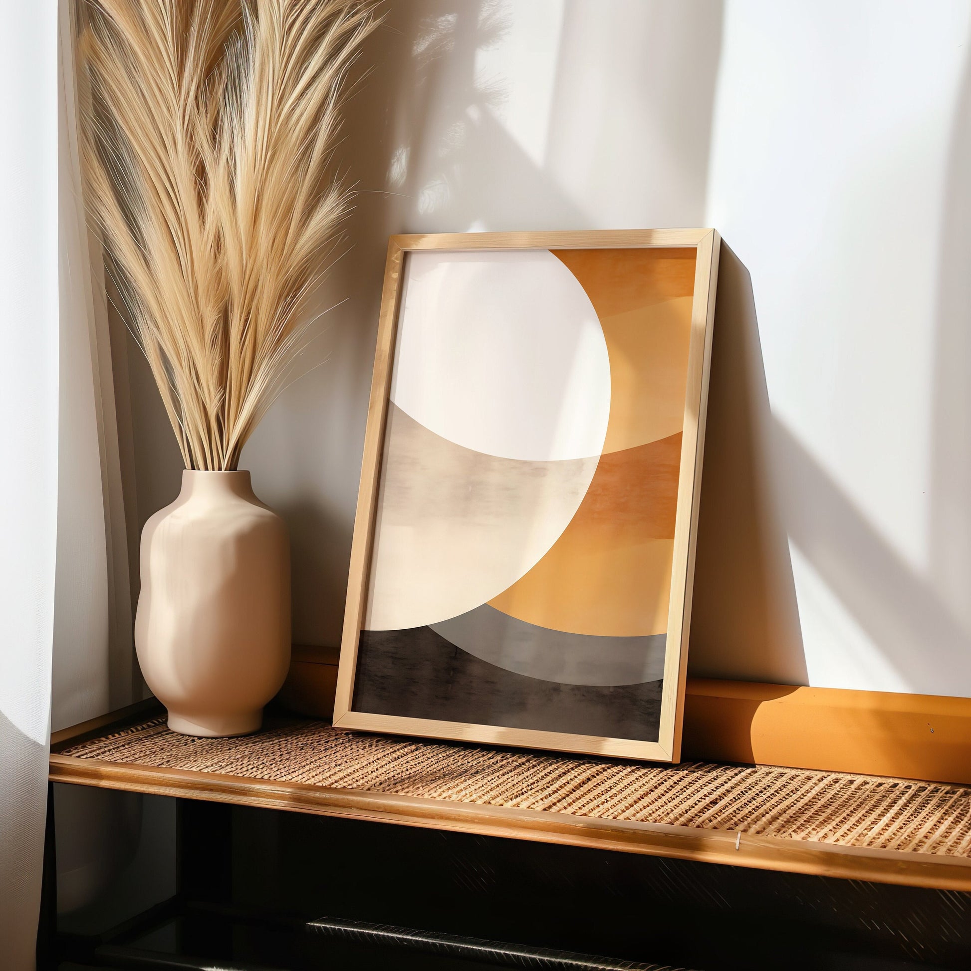 A minimalist abstract geometric poster in neutral tones, displayed on a windowsill with a cityscape view in the background, featuring a modern design with intersecting shapes in soft colors.