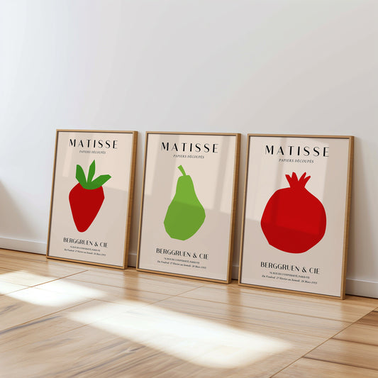 A minimalist set of Henri Matisse posters featuring a strawberry, pear, and pomegranate in bold red and green cut-out designs from the Berggruen & Cie 1953 collection.