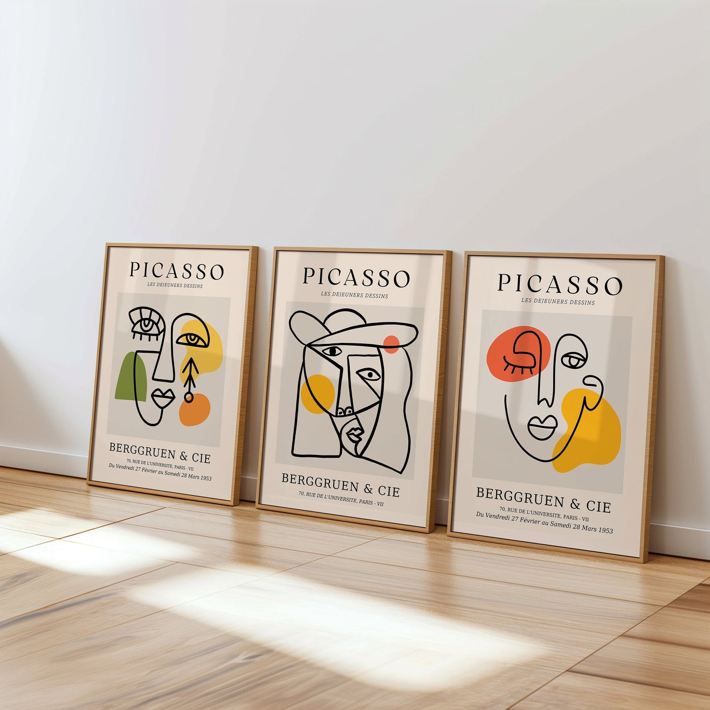 A set of three Picasso posters featuring abstract line art of faces, enhanced with bold and colorful accents, in minimalist frames.