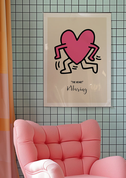 Keith Haring&#39;s &quot;The Heart&quot; poster featuring a bold pink heart running, framed in a modern minimalist room with a grid-patterned wall and a pink armchair, creating a playful and vibrant vibe.