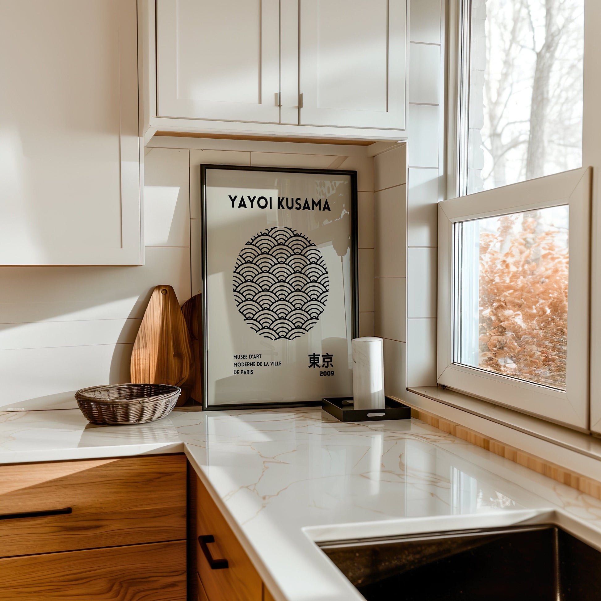 A minimalist black and white art print featuring Yayoi Kusama&#39;s iconic geometric wave design, inspired by traditional Japanese art, framed in a wooden frame and placed by a sunlit window.