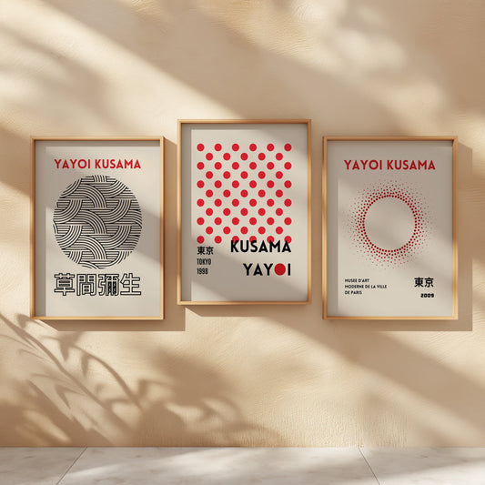 A set of three Yayoi Kusama posters featuring minimalist red dots and abstract line art patterns, framed in wood and displayed on a clean wooden floor.