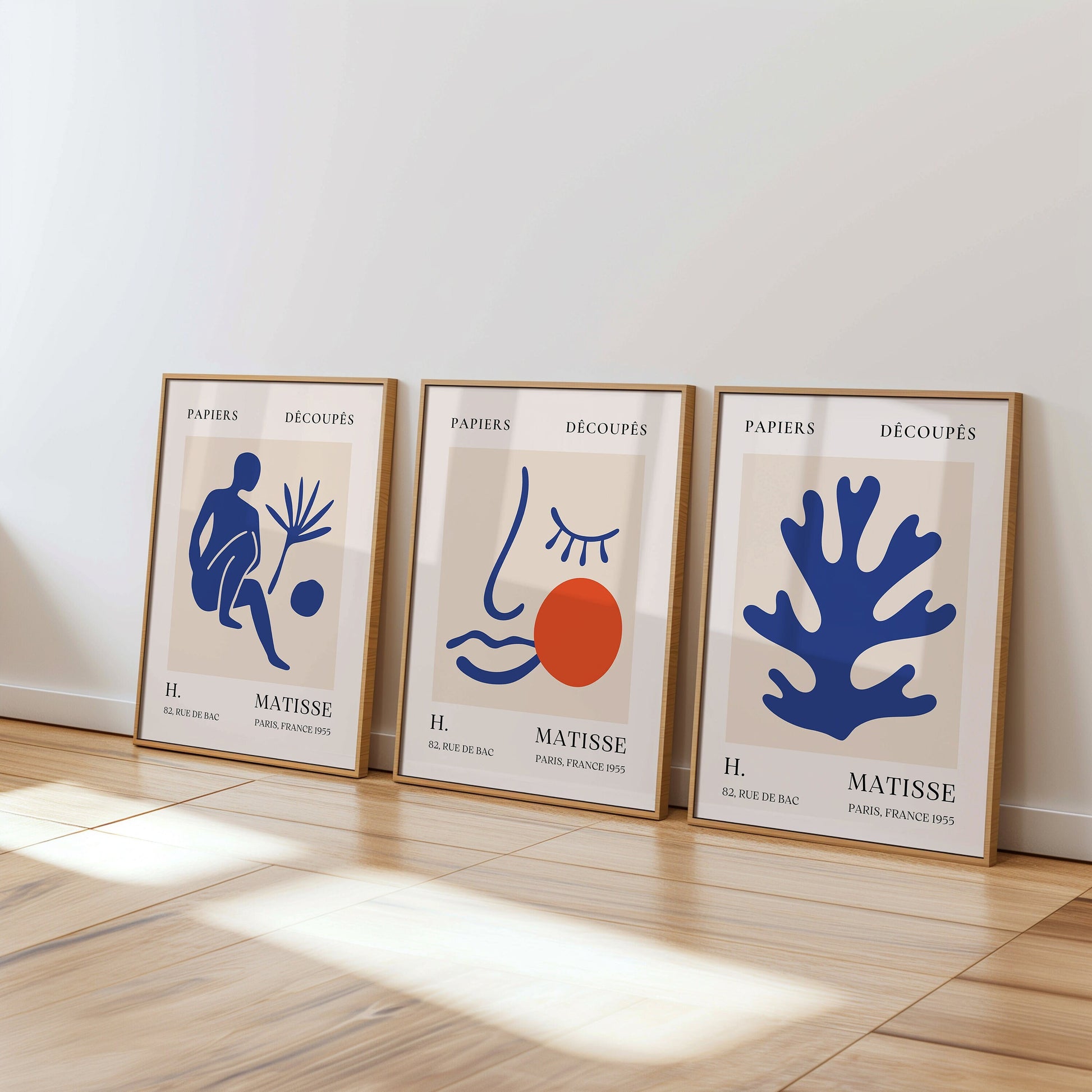 A set of three Henri Matisse posters featuring blue abstract cut-out designs and a minimalist face print from the Papiers Découpés collection, perfect for contemporary home decor.