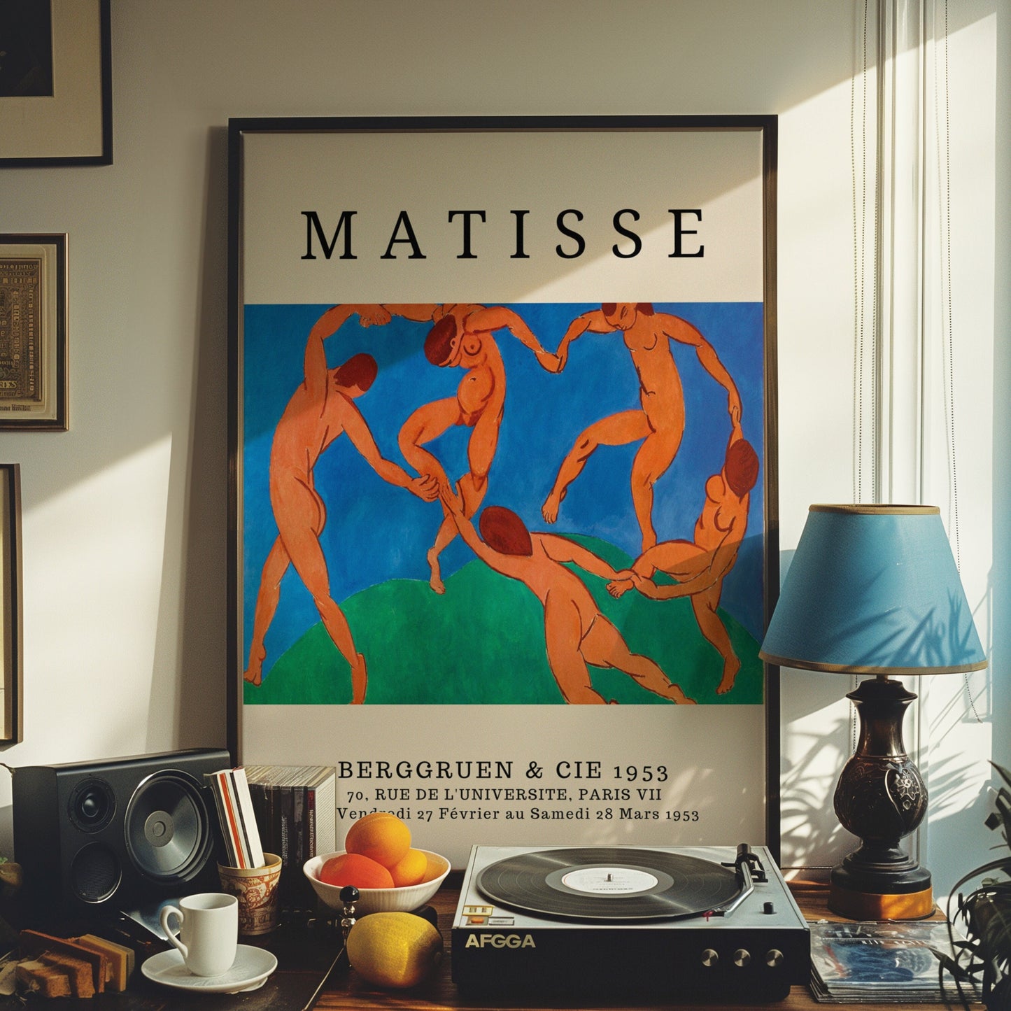 A Henri Matisse art print featuring &quot;The Dance&quot; with vibrant blue and red tones, displayed in a home setting with a turntable and decorative items.